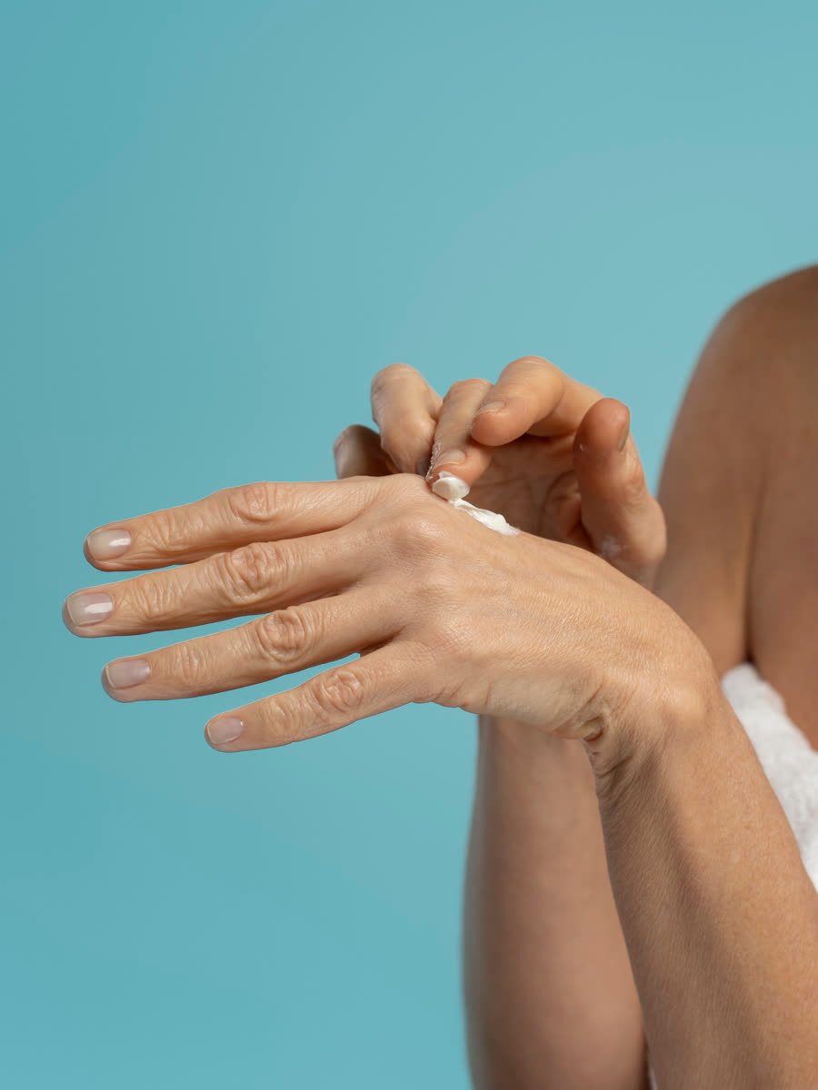 Mãos femininas recebendo creme de tratamento